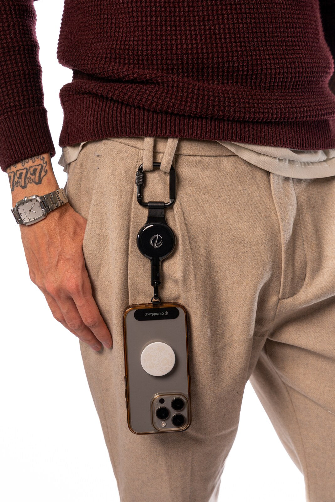Midnight ClutchLoop on beige trousers beneath a burgundy knit sweater